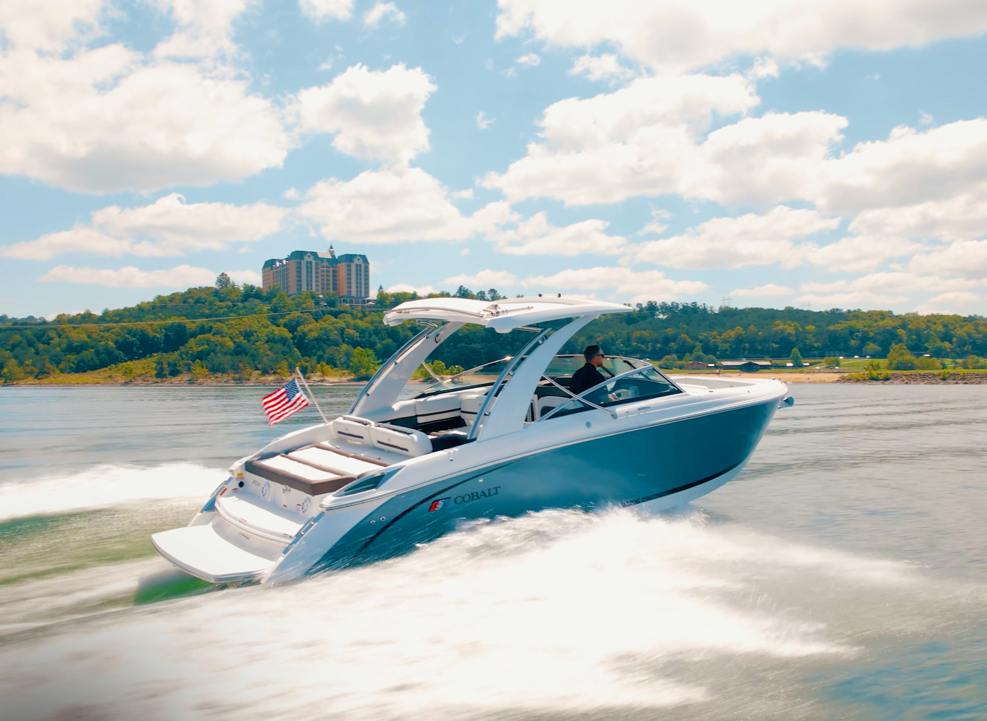 Cobalt boat cruising past Chateau on the Lake on Table Rock Lake near Branson, Missouri